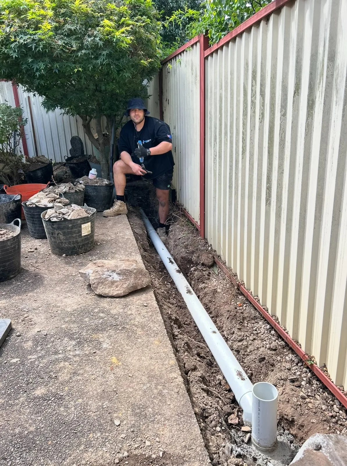A freshly dug trench across a backyard for new drainage