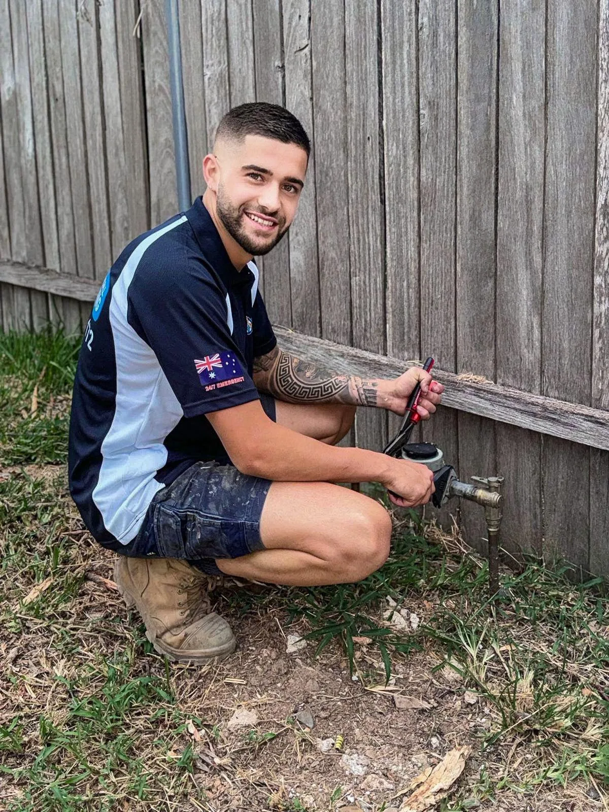 A plumber repairing an outdoor tap and pipe fitting